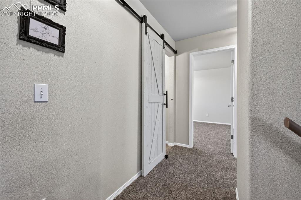 The main hallway on the 2nd floor. A barn door entrance to this bathroom also.