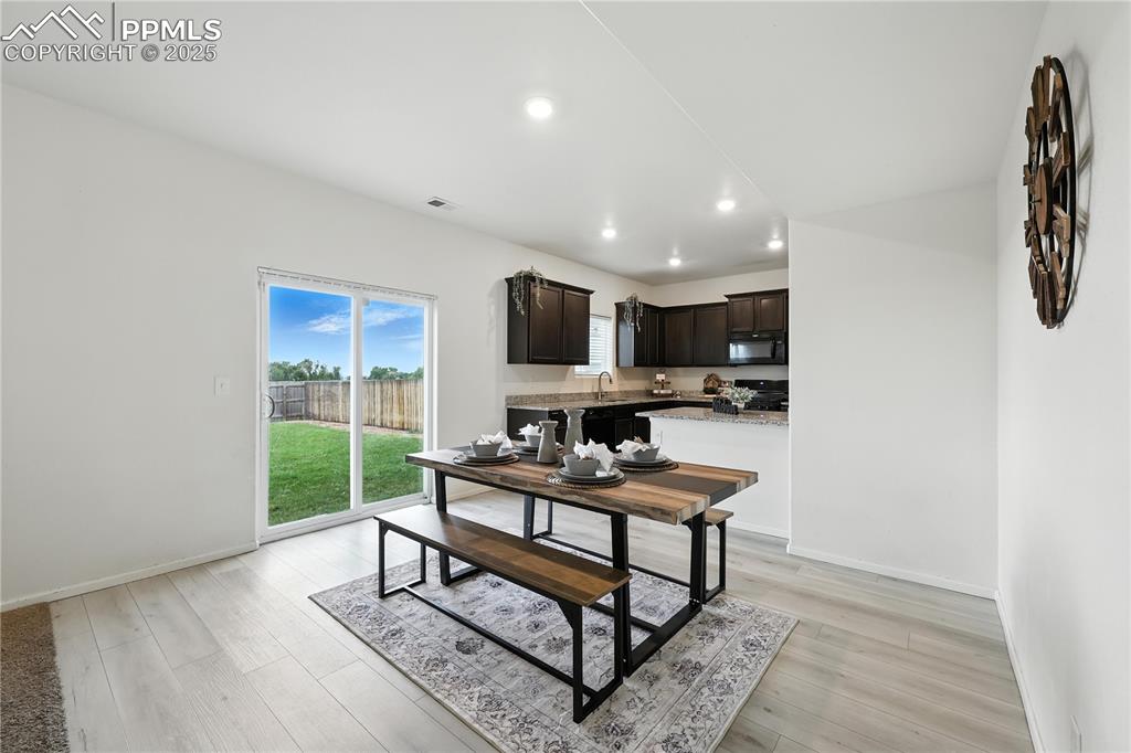 The Dining Area features wood laminate flooring and a slider that opens to a fully fenced backyard.