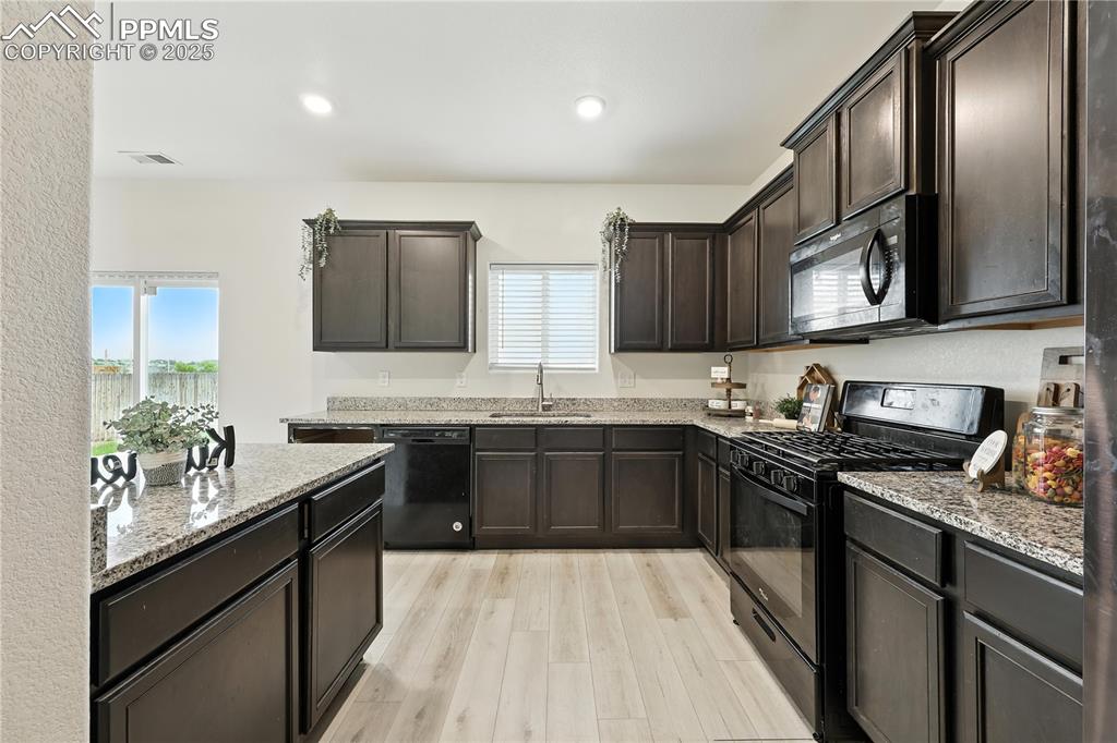 Appliances include a gas range oven, built in microwave, dishwasher, and refrigerator.