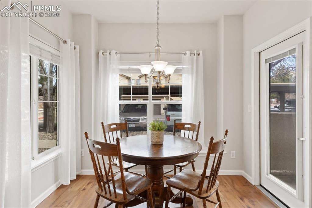 Dining area featuring light wood finished floors and suspended lighting