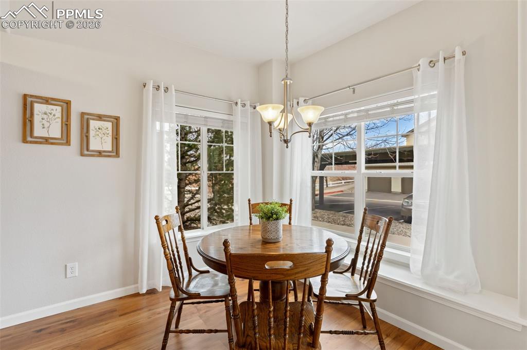 Dining space with suspended lighting and light wood finished floors