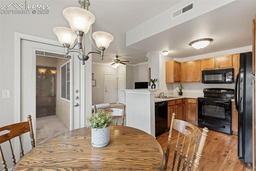 Dining room with a ceiling fan, crown molding, and light wood-style flooring