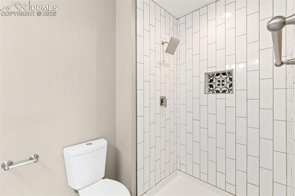 Updated master bath with tile floor, double vanity, and tile shower.