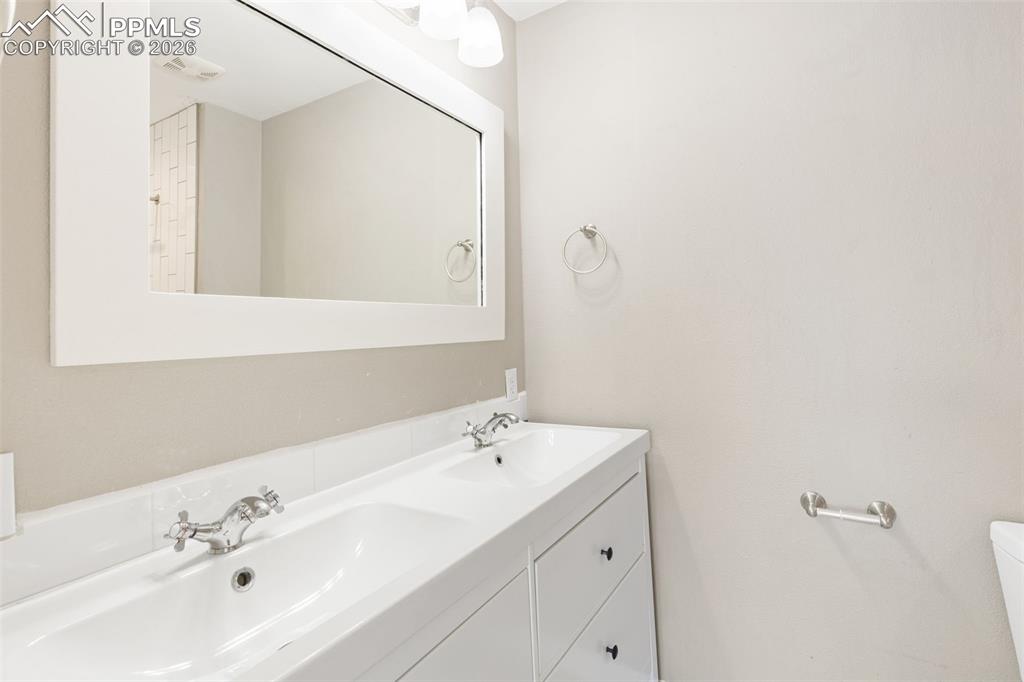 Updated master bath with tile floor, double vanity, and tile shower.