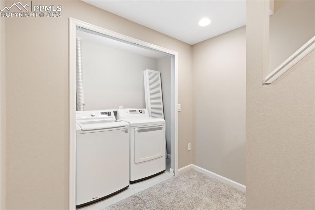 Bright and clean laundry area in the basement with newer tile floor.