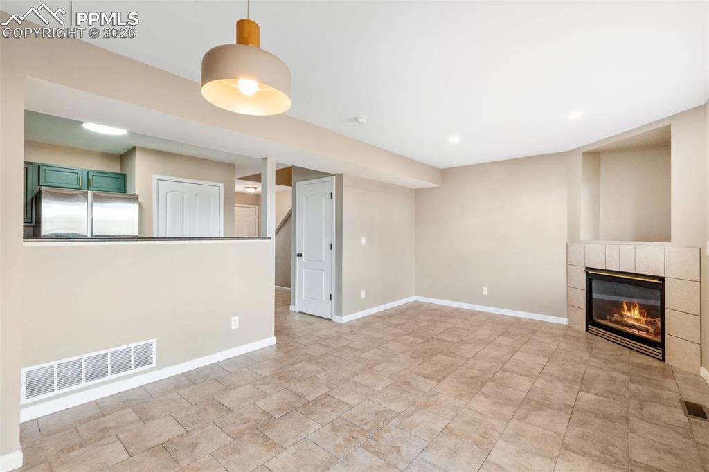 Updated living room with tile floor, gas fireplace; adjacent to dining area.