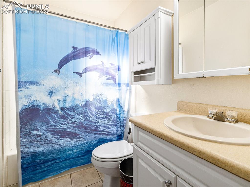 Bathroom featuring vanity, light tile patterned flooring, and a shower with curtain