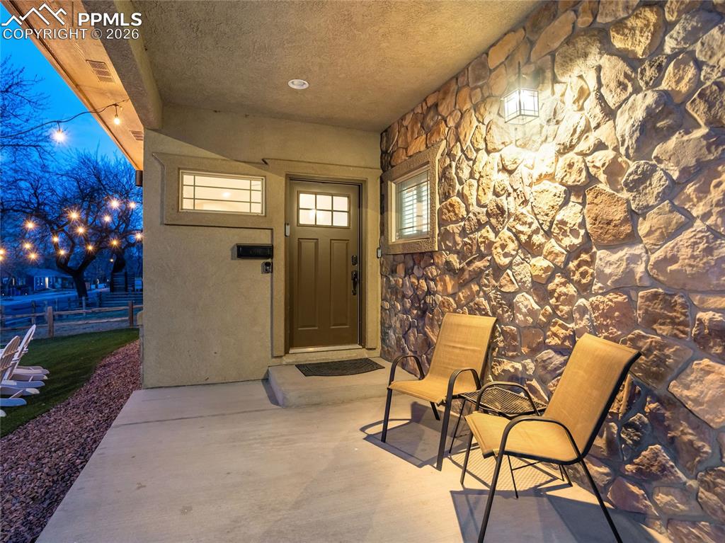 Covered front porch entry with dramatic stone accent wall provides a welcoming all-weather seating area.
