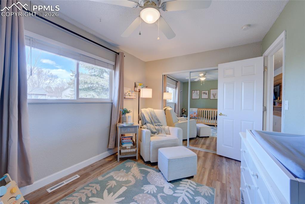 Bedroom with wood finished floors, a ceiling fan, and a closet