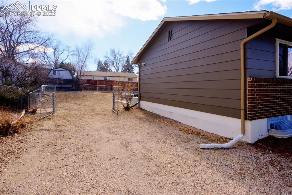 View of property exterior featuring a gate