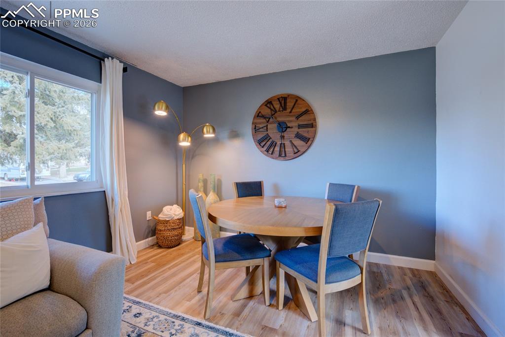 Dining space with wood finished floors and a textured ceiling