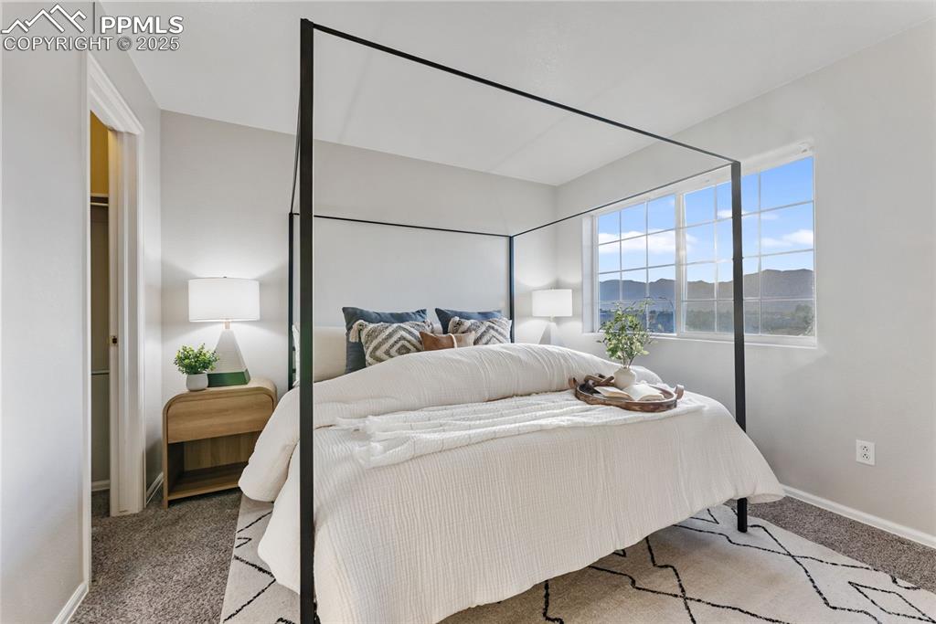 Carpeted bedroom featuring baseboards and a mountain view