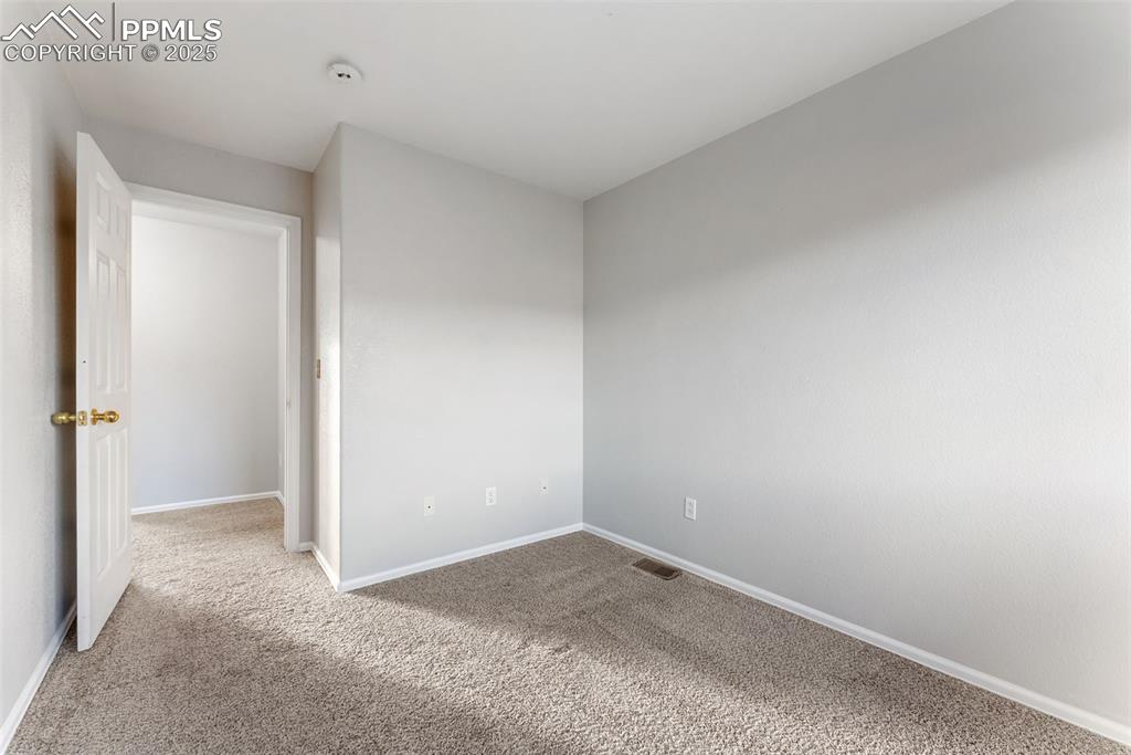 Carpeted spare room with baseboards