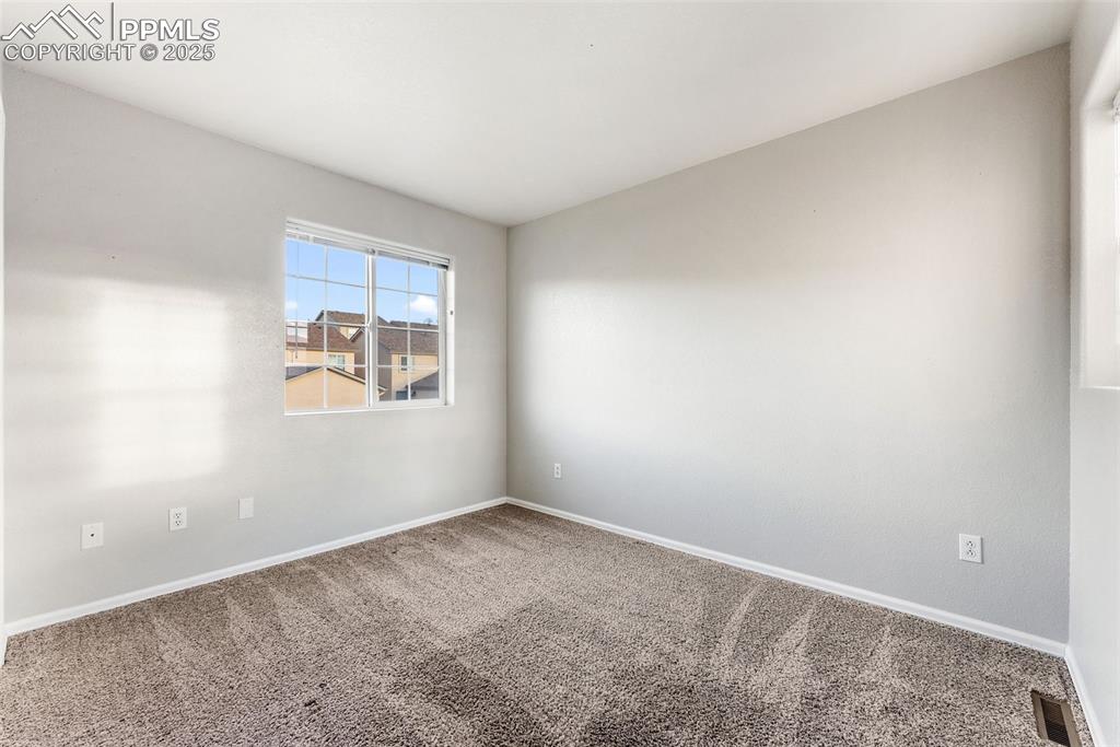 Carpeted empty room with baseboards