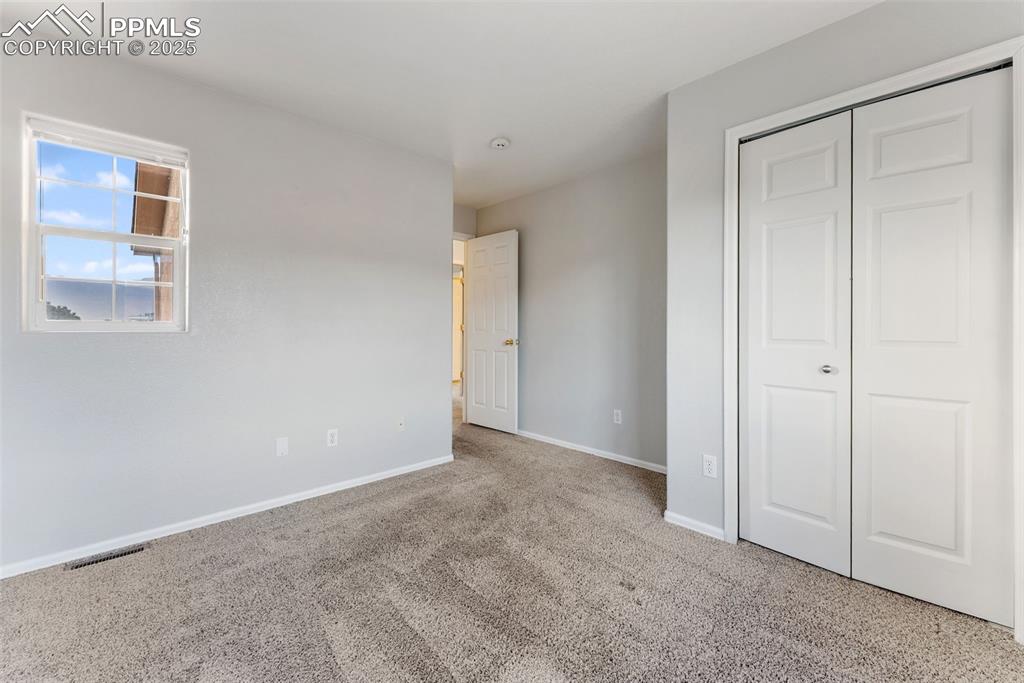 Unfurnished bedroom with carpet flooring and a closet