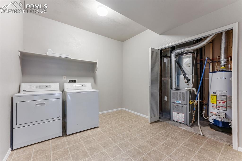 Laundry room with gas water heater, heating unit, and independent washer and dryer