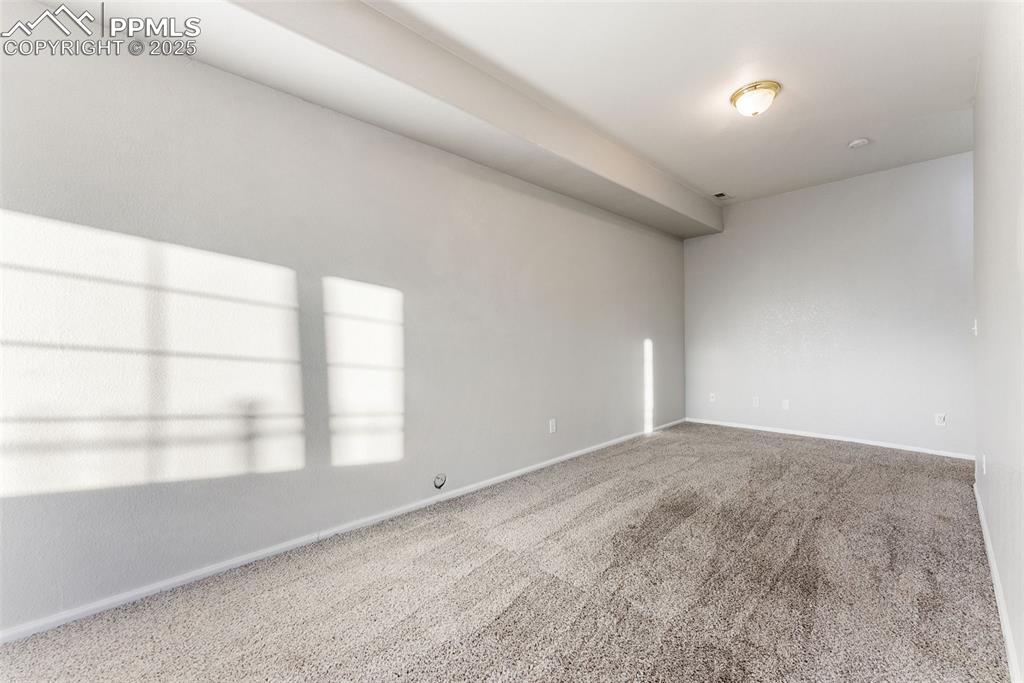 Carpeted spare room with baseboards