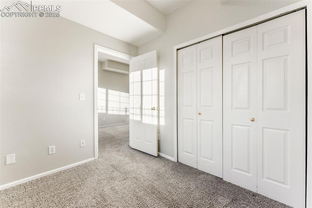 Unfurnished bedroom featuring carpet and a closet