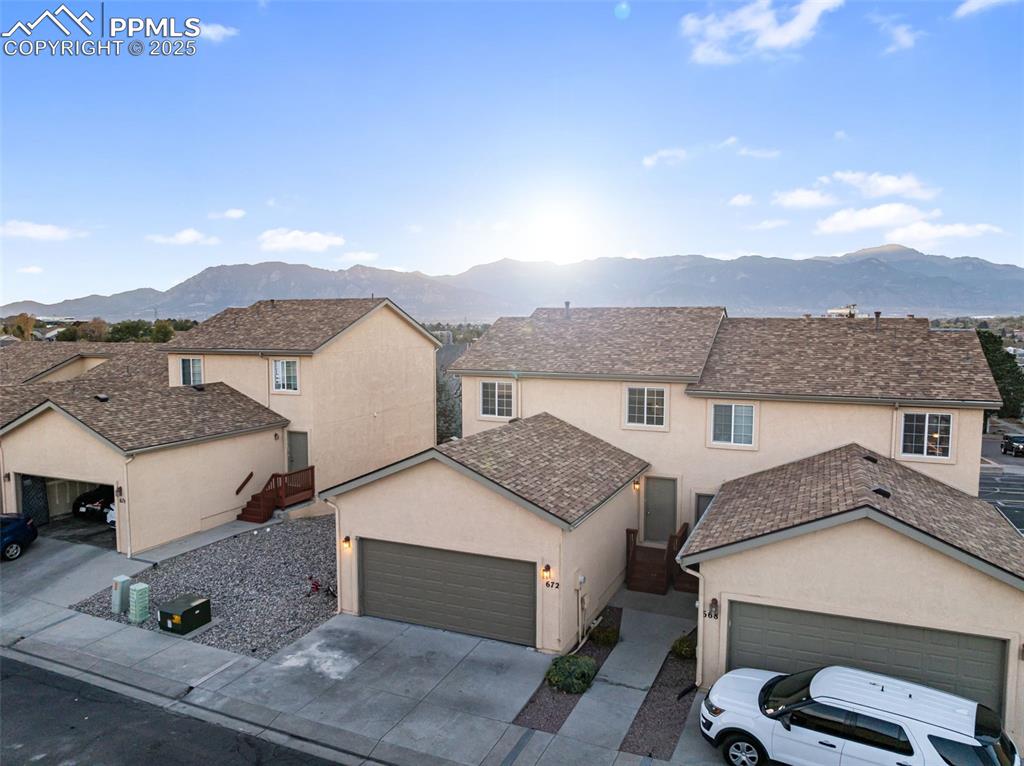 Traditional-style house with stucco siding, a mountain view, concrete driveway, and a garage