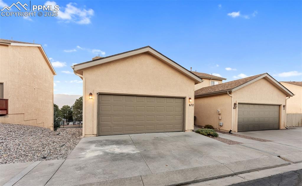View of front facade featuring stucco siding and concrete driveway