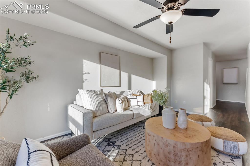 Living room with wood finished floors and a ceiling fan
