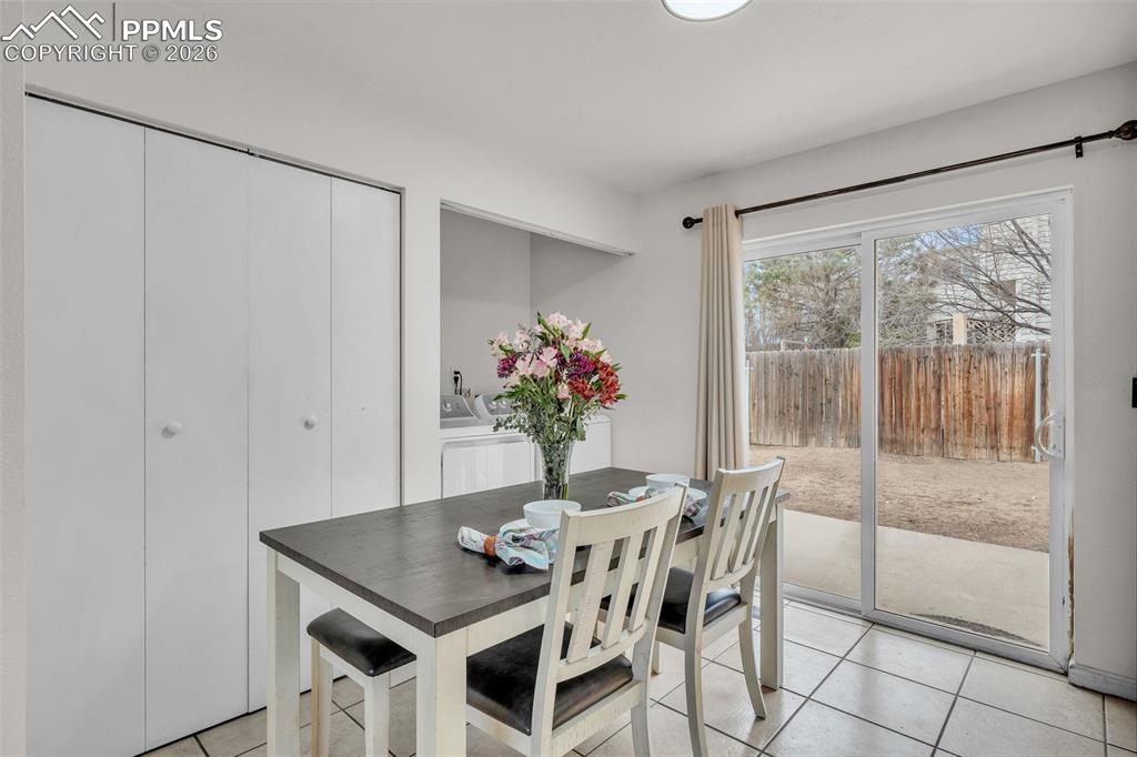 Dining area with light tile patterned floors and washer / dryer