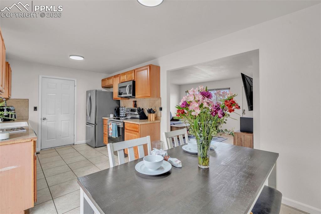 Dining room featuring light tile patterned flooring and baseboards