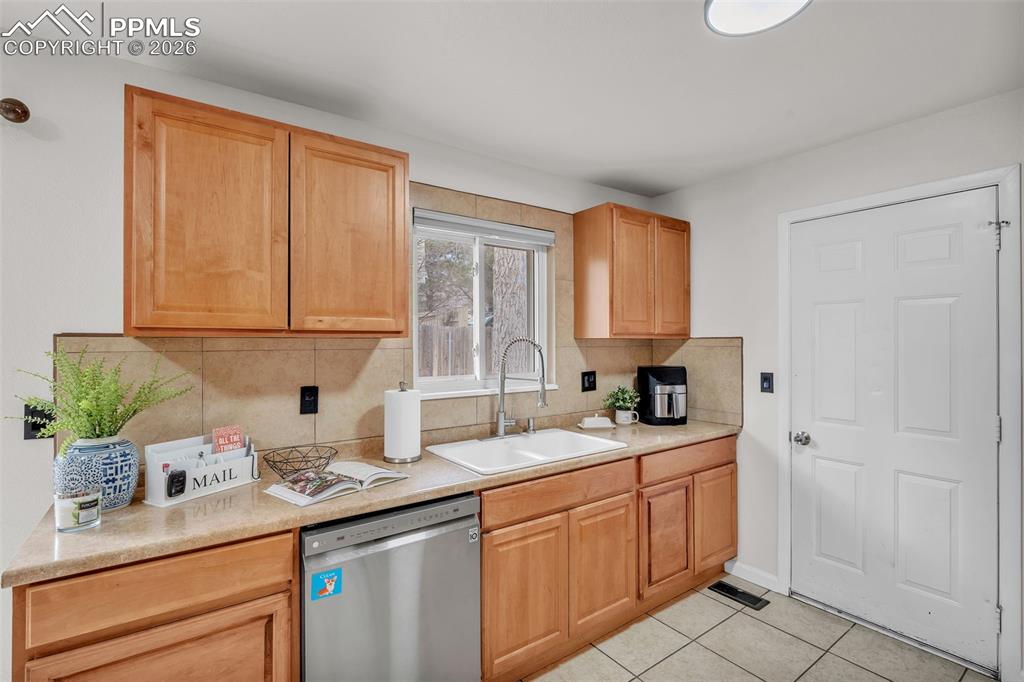 Kitchen featuring tasteful backsplash, dishwasher, and light countertops