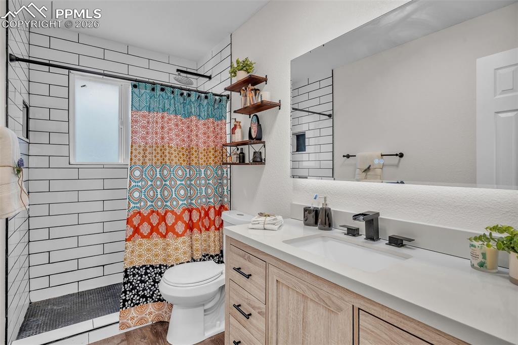 Full bath featuring vanity and a tile shower
