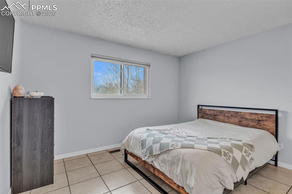 Bedroom with a textured ceiling and light tile patterned floors