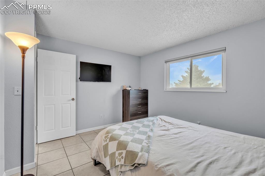 Bedroom with a textured ceiling and light tile patterned floors