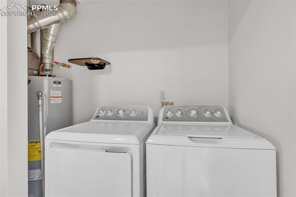 Laundry room featuring water heater and washing machine and dryer
