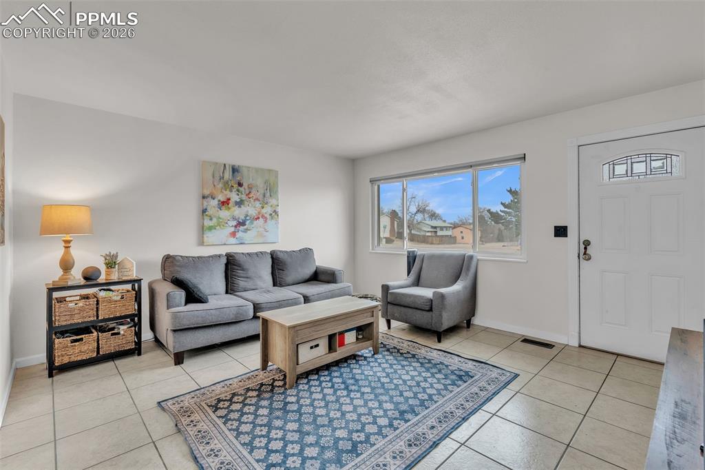 Living area featuring light tile patterned flooring and baseboards