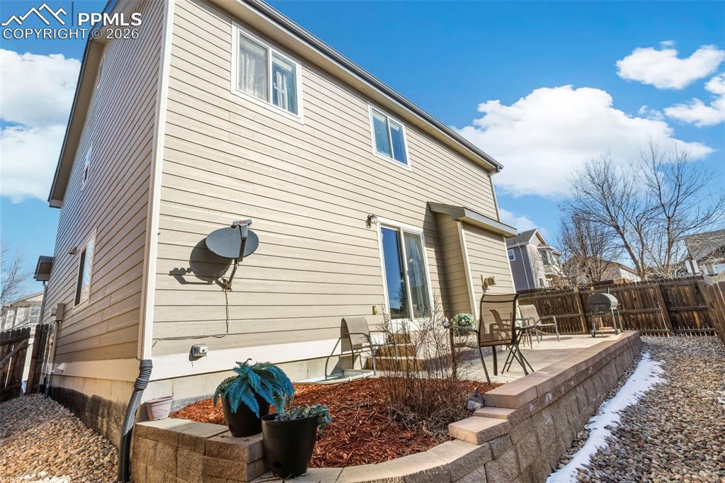 Back of house featuring deck, xeroscaping and privacy fence