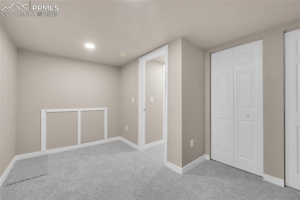 Basement with baseboards and light colored carpet