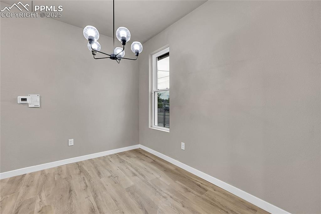 Unfurnished dining area with light wood-style floors and a chandelier