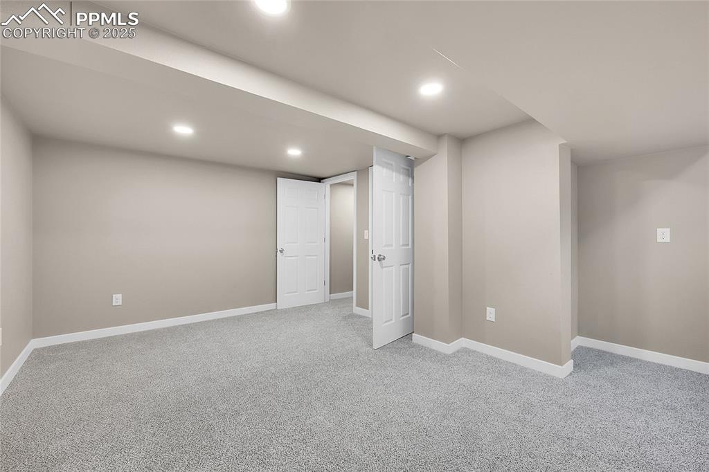 Finished below grade area with light colored carpet and recessed lighting
