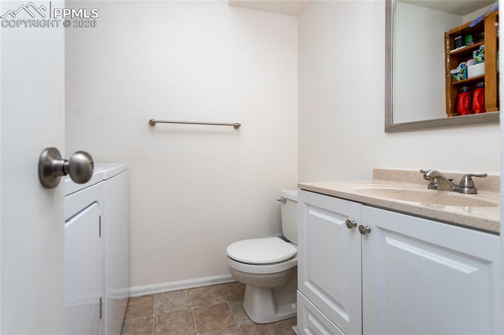 Half bathroom featuring vanity and toilet