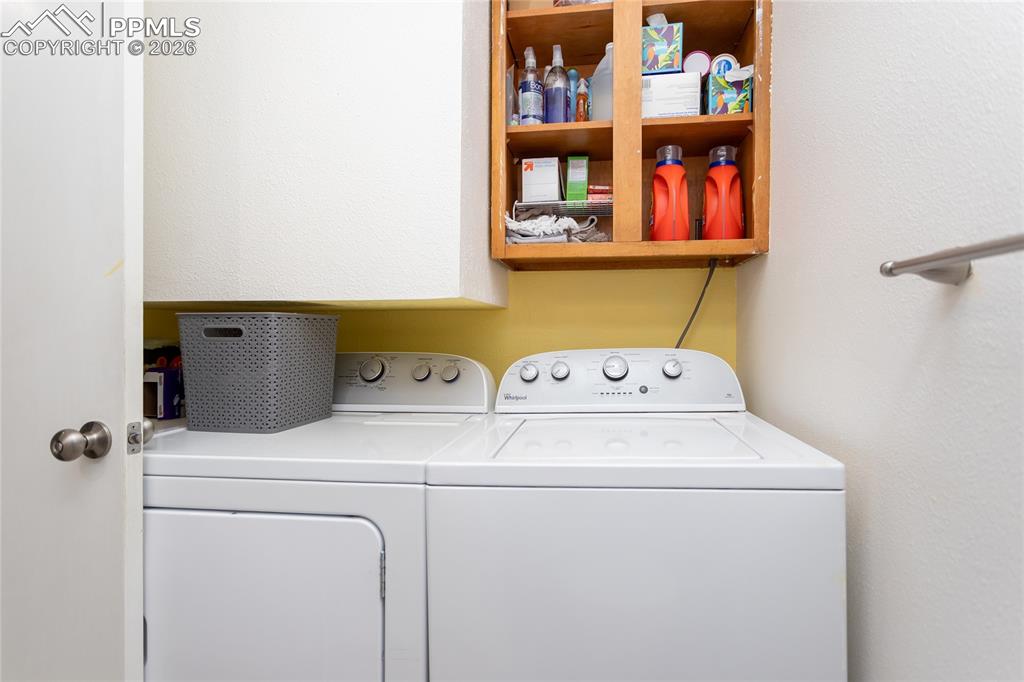 Laundry room with washer and clothes dryer and a textured wall