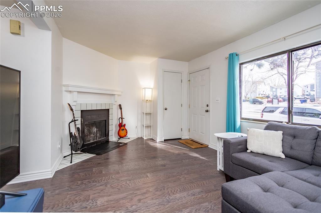 Living room featuring wood finished floors and a tiled fireplace