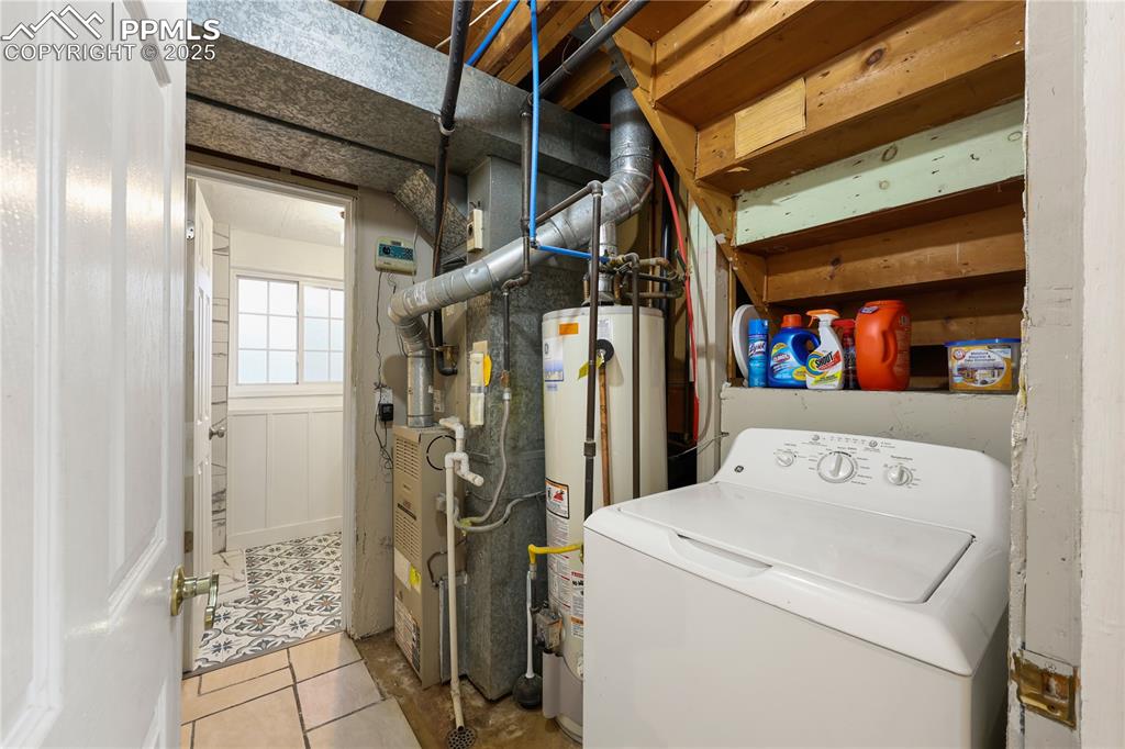 Laundry area featuring washer / dryer, water heater, light tile patterned floors, and heating unit
