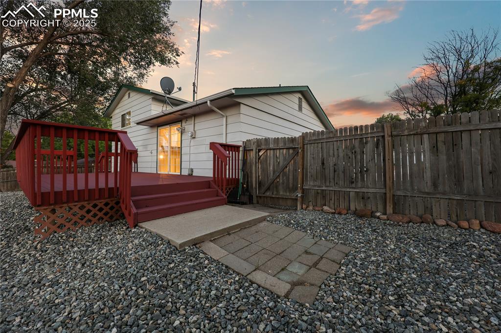 Rear view of property featuring a gate and a wooden deck