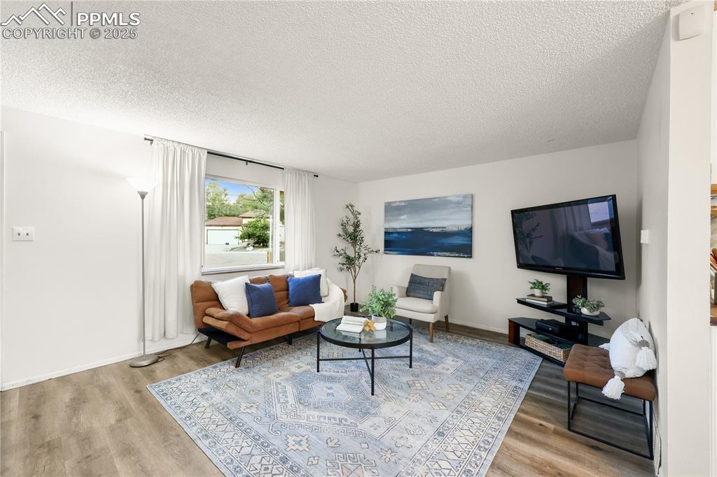 Living room with a textured ceiling and light wood finished floors