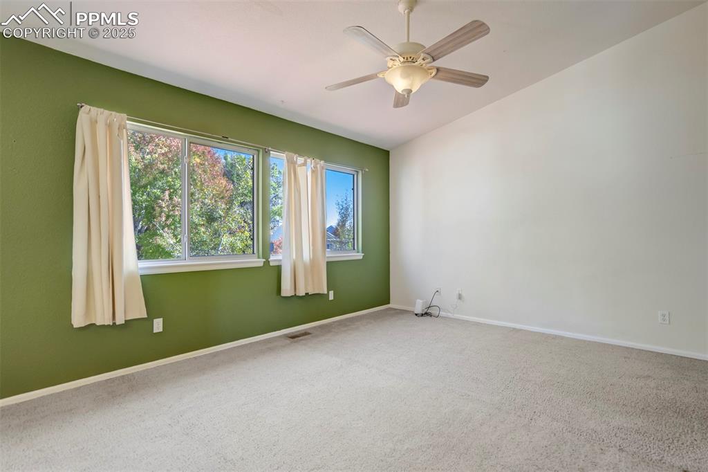 Spare room with carpet floors and a ceiling fan