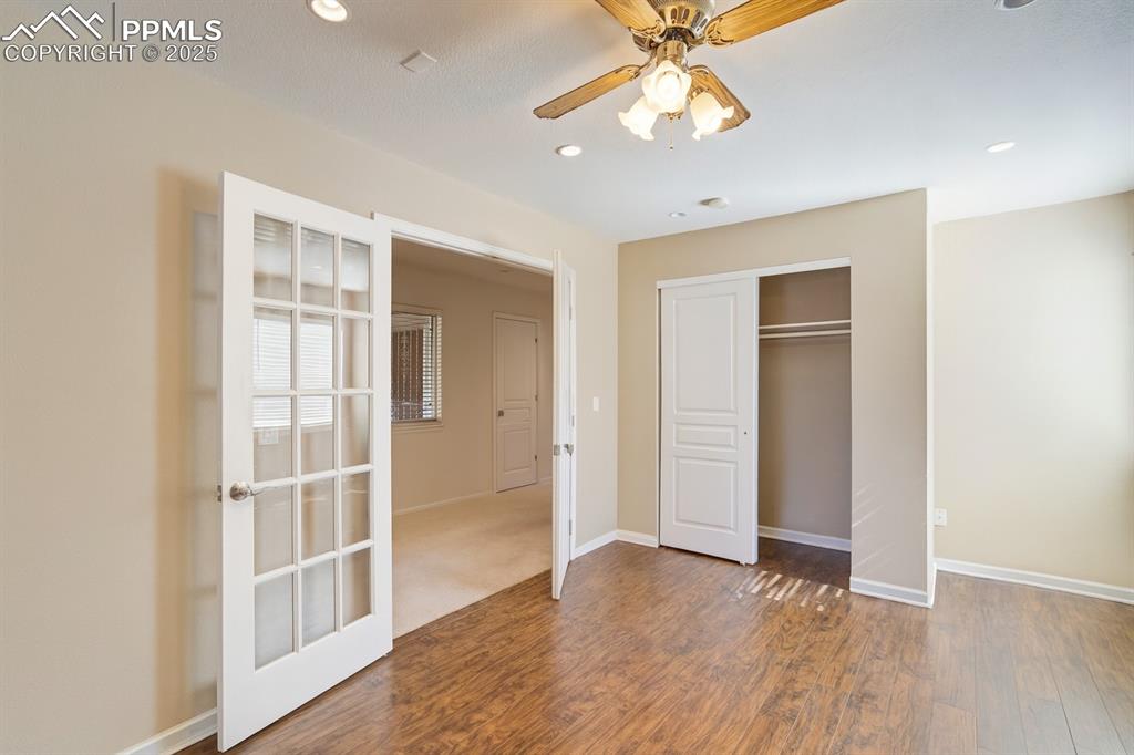 Unfurnished bedroom featuring wood finished floors, a ceiling fan, a closet, and recessed lighting