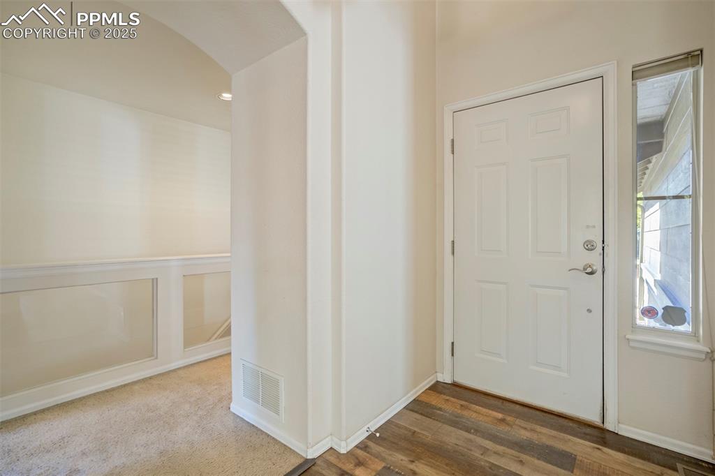 Foyer featuring arched walkways and wood finished floors