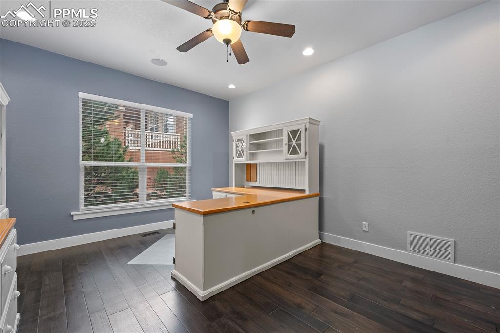 Main Floor Office with dark wood-style flooring, recessed lighting and a ceiling fan.