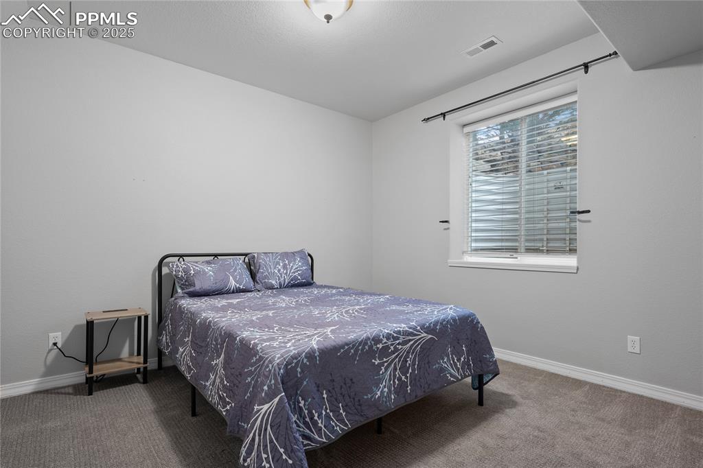Basement Bedroom with carpet floors.  One of two bedrooms in the basement.