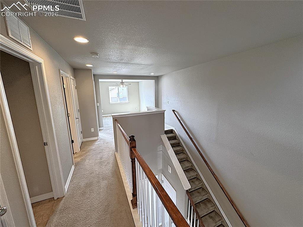 Upper-Level Hallway with Recessed Can Lights and Open Stairway