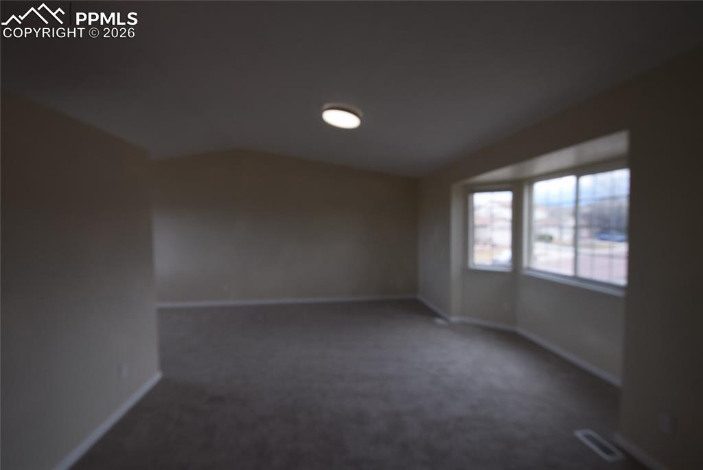 Spare room with carpet floors and vaulted ceiling